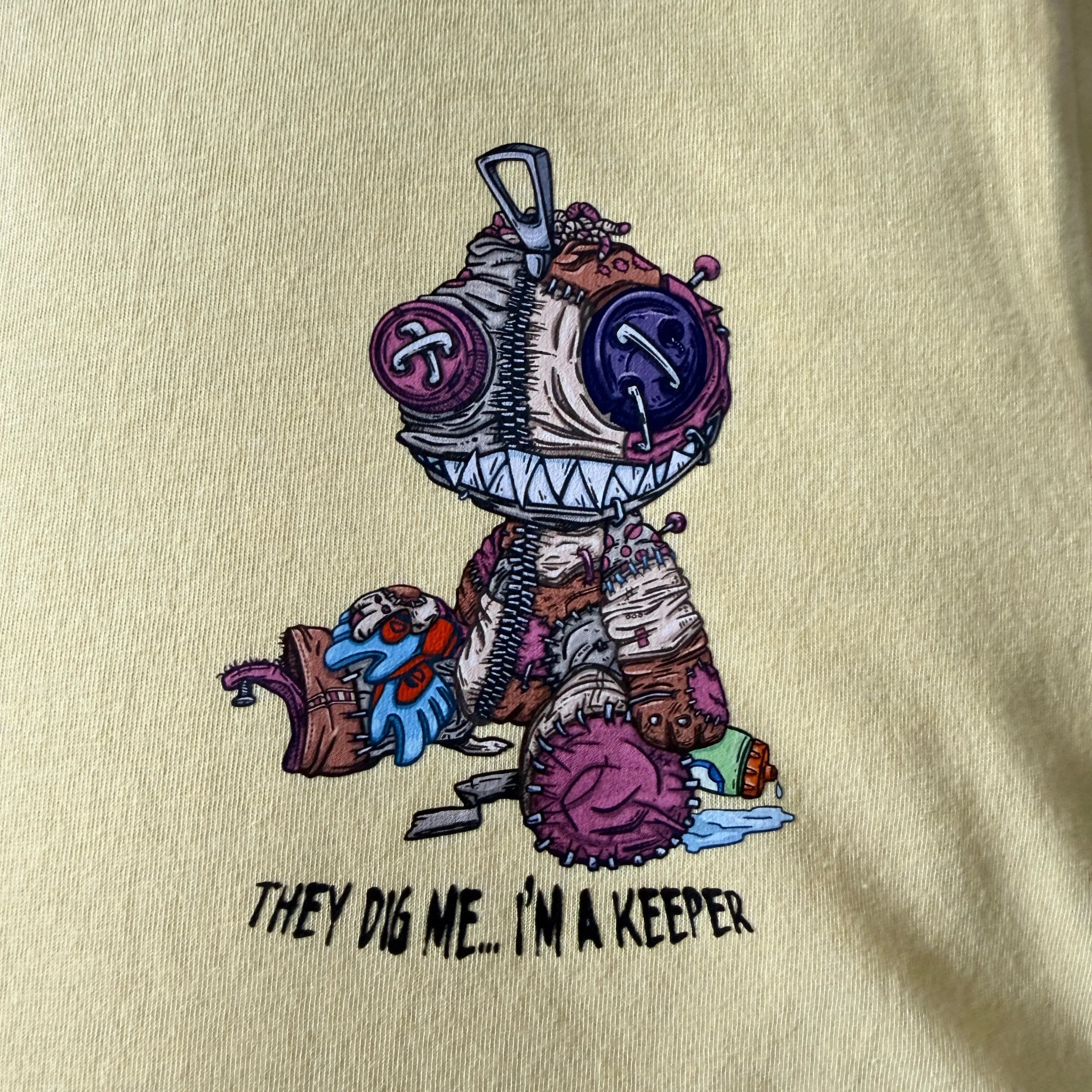 Beige t-shirt with a cartoon character and text on a beige background